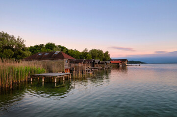 Fototapeta na wymiar Sonnenaufgang am Starnberger See mit Bootshütten