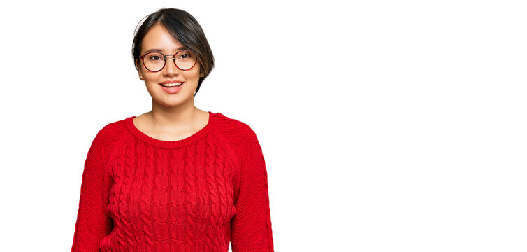 Young beautiful hispanic woman with short hair wearing casual sweater and glasses with a happy and cool smile on face. lucky person.