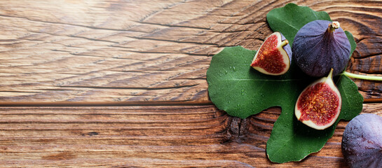 Detail of fresh figs spilled on a wooden table. Copy space for text or description.