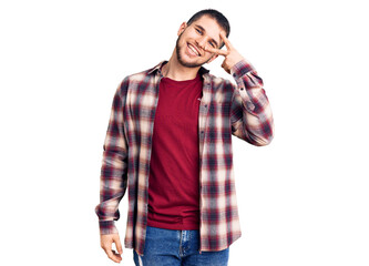 Young handsome man wearing casual shirt doing peace symbol with fingers over face, smiling cheerful showing victory