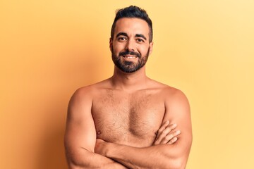Fototapeta premium Young hispanic man standing shirtless happy face smiling with crossed arms looking at the camera. positive person.