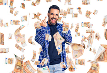 Young hispanic man wearing casual clothes showing middle finger doing fuck you bad expression,...