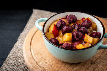Oatmeal with peach and cherry on black background.