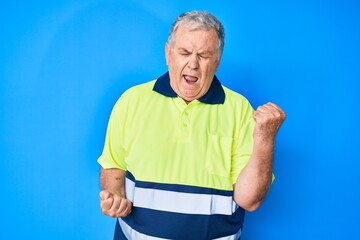 Senior grey-haired man wearing reflective t shirt celebrating surprised and amazed for success with arms raised and eyes closed