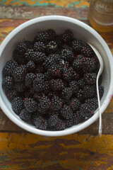 Blackberries with elderflower cordial in white bowl 