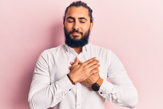 Young arab man wearing casual clothes smiling with hands on chest with closed eyes and grateful gesture on face. health concept.