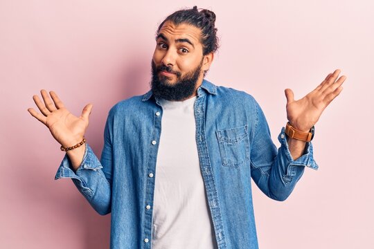 Young arab man wearing casual clothes clueless and confused with open arms, no idea and doubtful face.