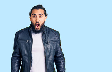 Young arab man wearing casual leather jacket afraid and shocked with surprise and amazed expression, fear and excited face.