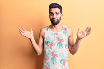 Young handsome man with beard wearing summer sleeveless t-shirt clueless and confused with open...