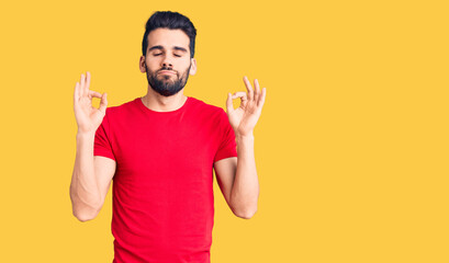 Young handsome man with beard wearing casual t-shirt relax and smiling with eyes closed doing meditation gesture with fingers. yoga concept.