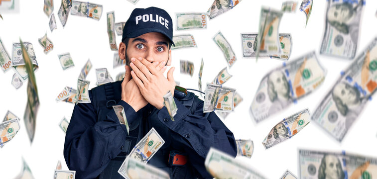 Young handsome man with beard wearing police uniform shocked covering mouth with hands for mistake. secret concept.