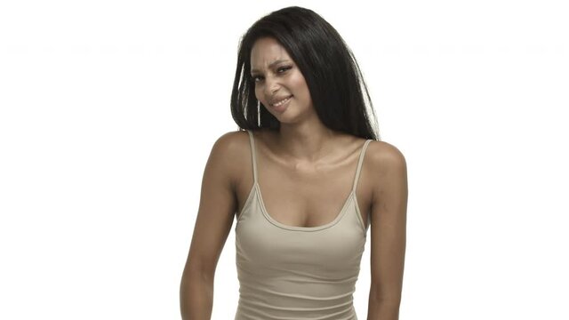 Studio shot of humble attractive african-american girl in beige tank-top, waving away at camera and smiling, express gratitude, flattered for compliments, standing over white background