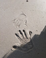 Hand imprint on the beach sand
