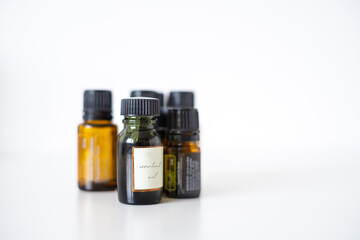 Brown and green small glass bottles with essential oils on a white background. Concept for self-care