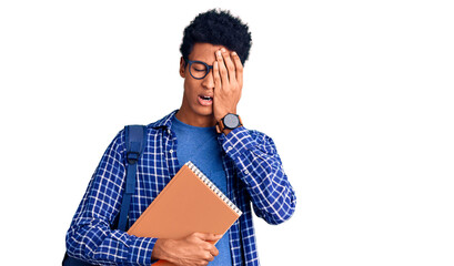 Young african american man wearing student backpack holding book yawning tired covering half face, eye and mouth with hand. face hurts in pain.