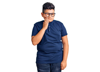 Little boy kid wearing casual clothes and glasses touching mouth with hand with painful expression because of toothache or dental illness on teeth. dentist