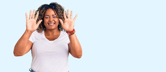 Obraz na płótnie Canvas Young african american plus size woman wearing casual clothes showing and pointing up with fingers number ten while smiling confident and happy.