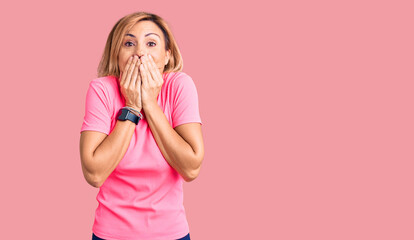 Young blonde woman wearing sportswear laughing and embarrassed giggle covering mouth with hands,...
