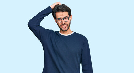 Young hispanic man wearing casual clothes and glasses confuse and wonder about question. uncertain...