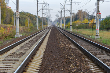 Fototapeta na wymiar Railway track with electricity pylons in perspective view go into the horizon