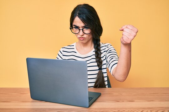 Brunette Teenager Girl Working Using Computer Laptop Annoyed And Frustrated Shouting With Anger, Yelling Crazy With Anger And Hand Raised