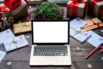 Laptop computer with white blank empty mock up screen monitor on Merry Christmas decorated table...