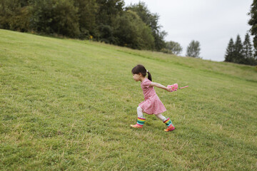 young girl running in the summer garden in the morning