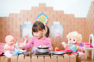 young  girl pretend play babysitting with baby doll at home