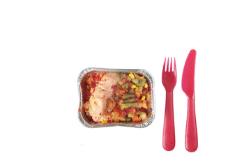 delivery menu concept - foil boxe with fish and vegetables, fork and knife isolated on white background flat lay