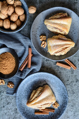 Fototapeta na wymiar Rolled triangle pies with walnut and cinnamon