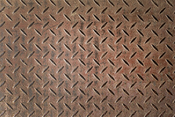 Abstract background of old rusty diamondplate rusty metal panel. Grunge brown rough grip industrial steel texture pattern