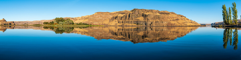 Fototapeta na wymiar Panorama of Eroded Basalt Cliffs Reflected in the Palouse River as it Joins the Snake River in Eastern Washington