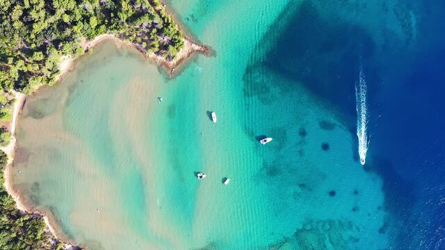 Top down aerial footage of an idyllic bay and boat sailing by in the Rab island on the Adriatic sea in Croatia