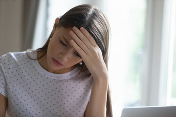 Head shot frustrated young beautiful girl feeling depressed, having financial problems or difficulties with calculating monthly budget or bank loan payments alone at home, life troubles concept.