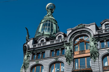 Saint Petersburg, Russia, 11.10.2020. Green decorative historic Art Nouveau Zinger building. Beautiful facade with big windows, glass dome, sculptures. Blue sky backdrop. View from griboyedov canal