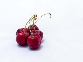 Fresh ripe juicy red cherries, several berries on a white background