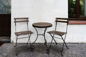 Outdoor office relaxation area with metal forged small table and chairs. - 384645527