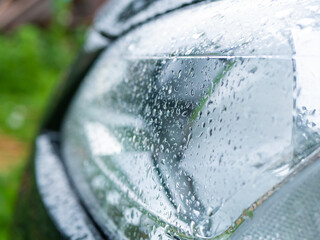 Water drops after rain on the headlight of the car
