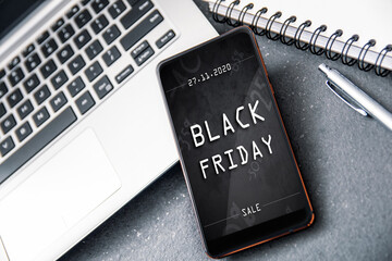 Smartphone with black friday banner on the screen lying on desk. Conception incoming promotion in e-commerce