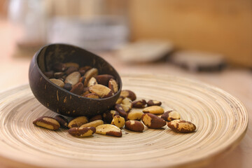 Brazil nuts spilled from a coconut bowl. They are notable for diverse content of micronutrients, especially a high amount of selenium.