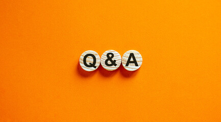 Concept text 'Q and A' on wooden circles on a beautiful orange  background. Business concept. Copy space.