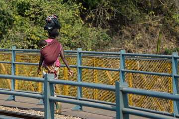 Woman with baby crossing thee bridge between ZAMBIA and ZIMBABWE - obrazy, fototapety, plakaty