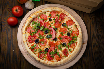 pizza with sausage, cheese, tomatoes and herbs
