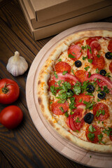 pizza with sausage, cheese, tomatoes and herbs
