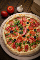 pizza with sausage, cheese, tomatoes and herbs
