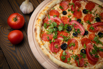 pizza with sausage, cheese, tomatoes and herbs

