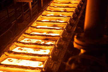 liquid metal in the molds on the conveyor belt at the steel mill