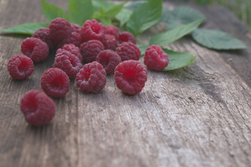 Ripe raspberries on a wooden table.