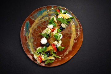 Cheese and fruit salad on a handmade plate. Mozzarella, blue cheese, parmesan, zucchini rolls,...