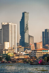 Obraz premium City Skyline as Seen from the Tourist Boat on Chao Phraya River at Sunset in Bangkok, Thailand